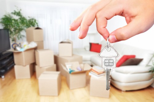 Professional movers carrying household items through a Sutton home
